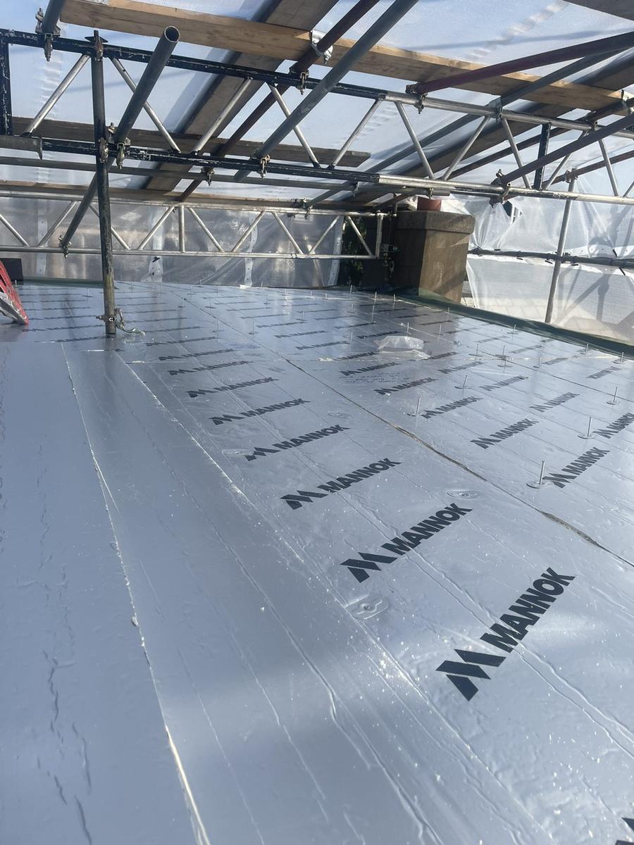 PIR insulation boards fixed across a flat roof under temporary cover, The Grange