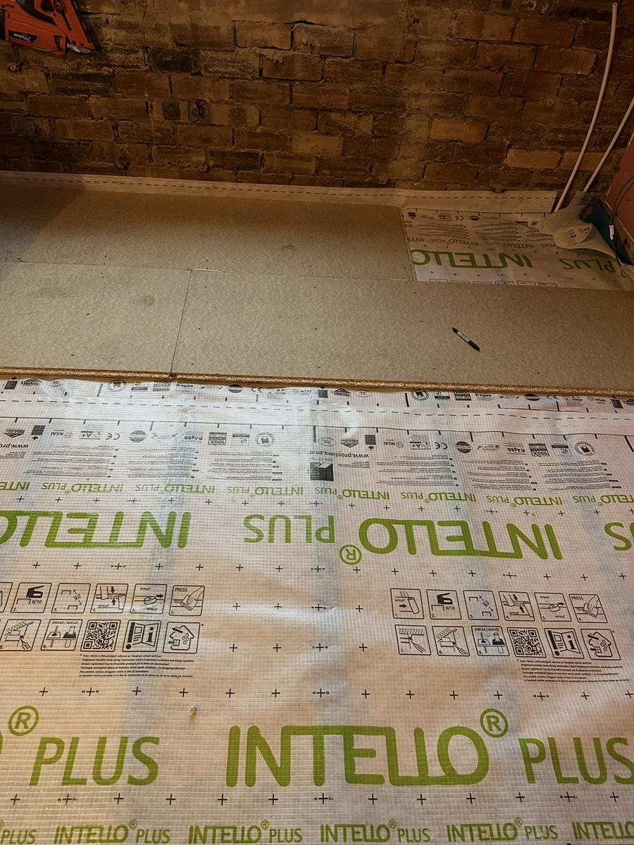 New floor boards going down over the membrane against a brick wall, Greenbank