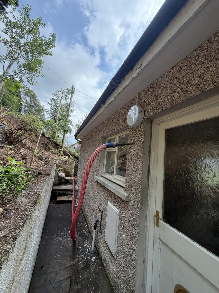 Cavity wall injection through roughcast at the rear of a Highland bungalow