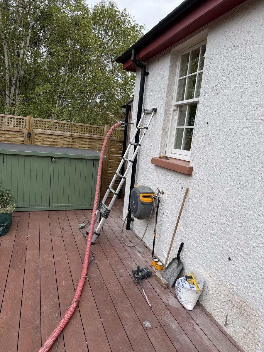 Hose and ladder set up for high-level cavity injection on a rendered wall, North Berwick