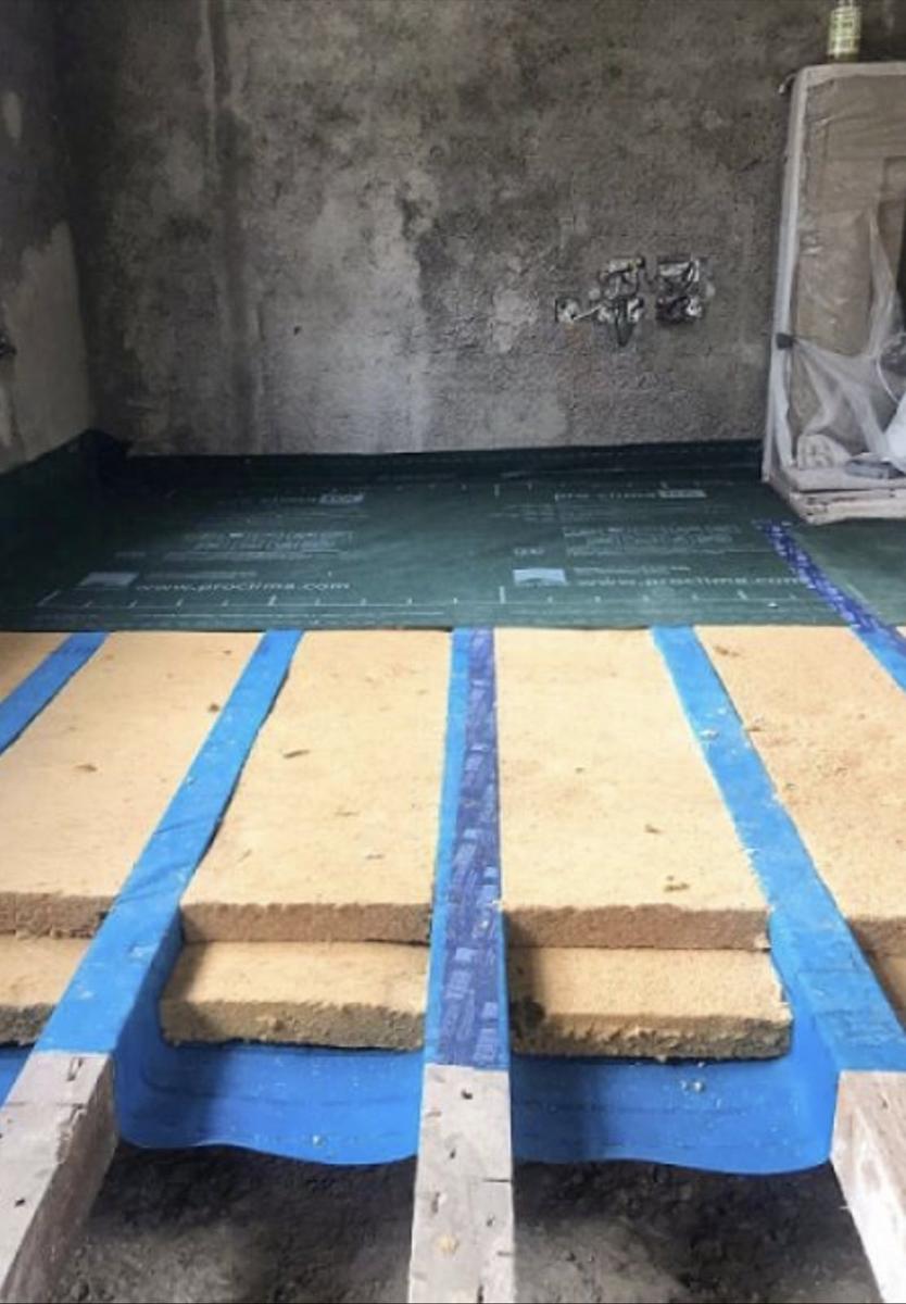 Insulation fitted between floor joists over a breathable membrane